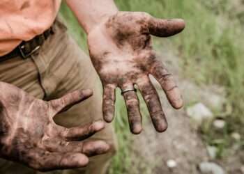 A man with his hands covered with mud