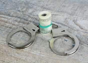 a pair of scissors and a roll of money on a table